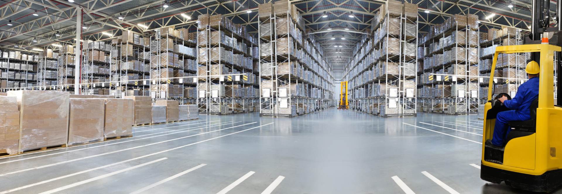Huge distribution warehouse with high shelves and loaders. Bottom view.